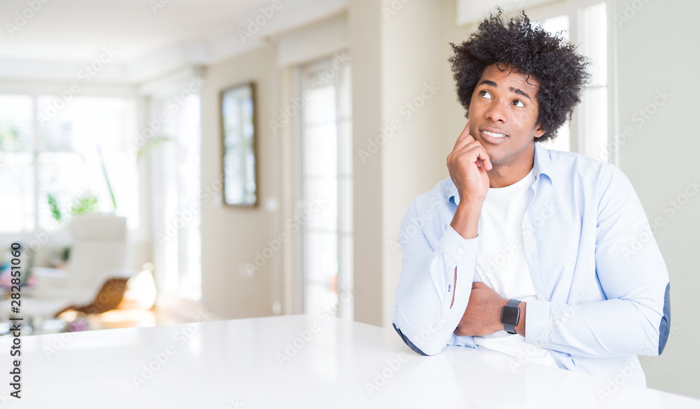 African American man at home with hand on chin thinking about question, pensive expression. Smiling with thoughtful face. Doubt concept. African American man at home with hand on chin thinking about question, pensive expression. Smiling with thoughtful face. Doubt concept.