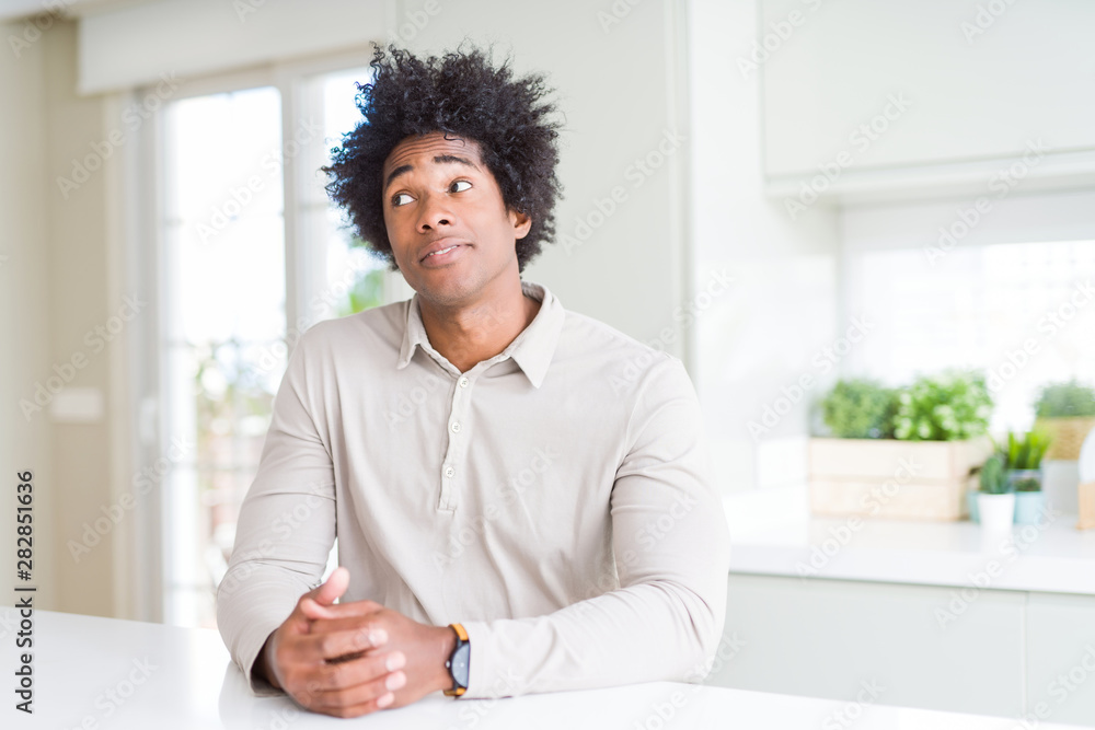 African American man at home smiling looking side and staring away thinking. African American man at home smiling looking side and staring away thinking.