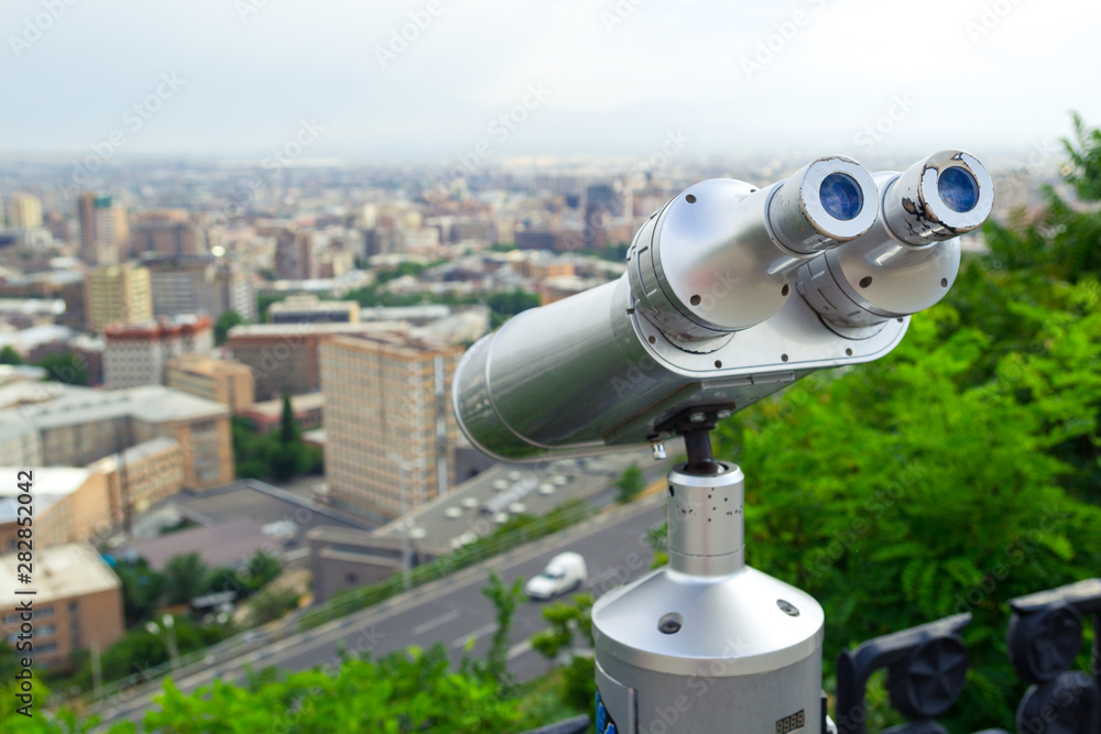 Tourist binoculars. View of the city landscape. Summer time. Travel concept