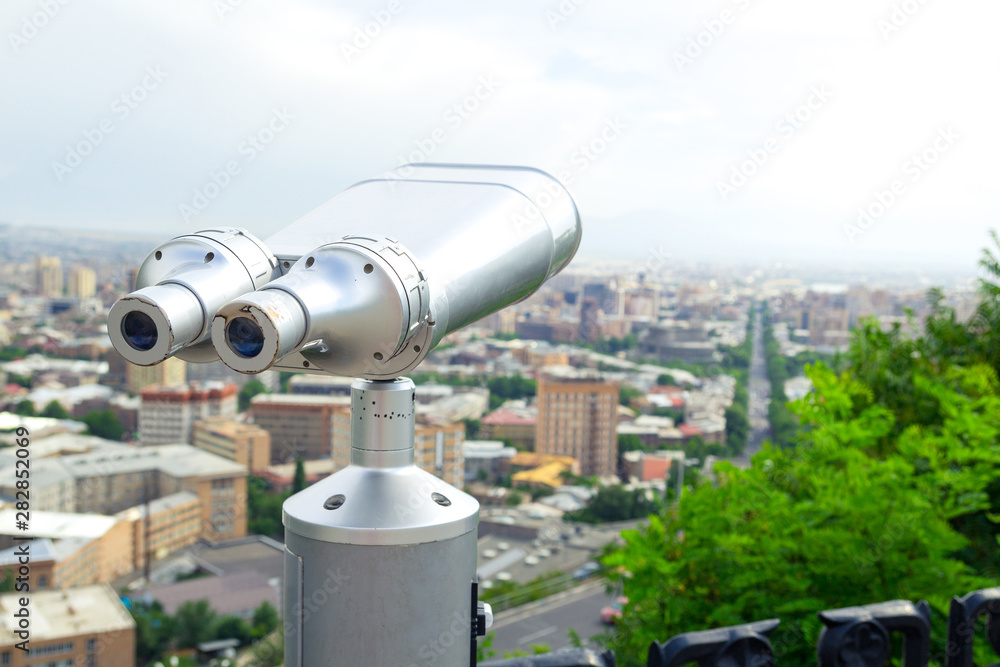 Tourist binoculars. View of the city landscape. Summer time. Travel concept Tourist binoculars. View of the city landscape. Summer time. Travel concept