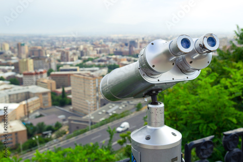 Tourist binoculars. View of the city landscape. Summer time. Travel concept