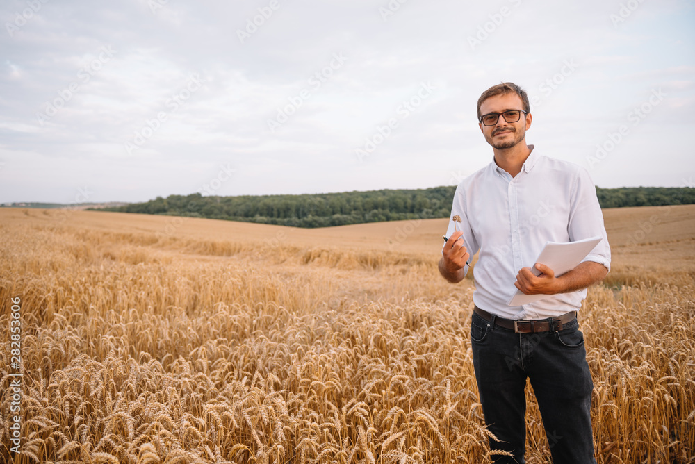 young farmer engineer standing on wheat field young farmer engineer standing on wheat field