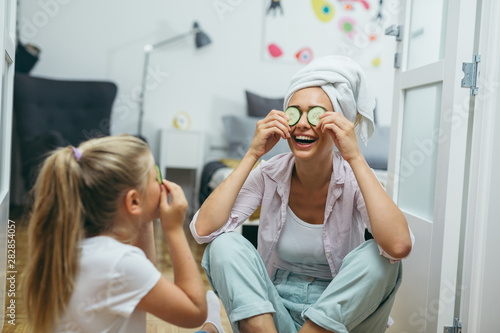 mother and daughter having great time together ta home. skin treatment concept photo