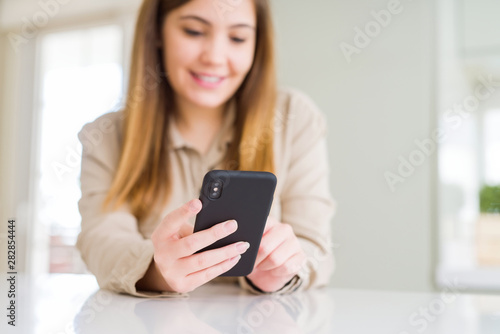Close up of woman using smartphone and smiling confident