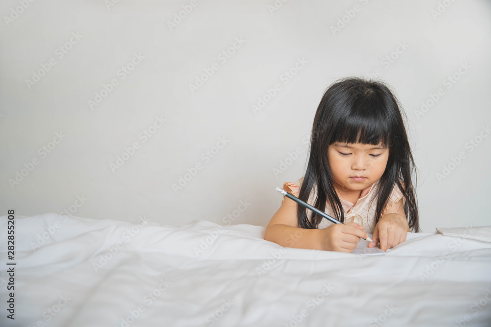 a little girl learning to write at home. Happy little girl writing in her notebook. Children and education concept. a little girl learning to write at home. Happy little girl writing in her notebook. Children and education concept.
