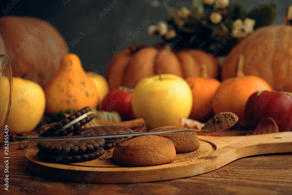 Cookies  with pumpkins and apples on the table.