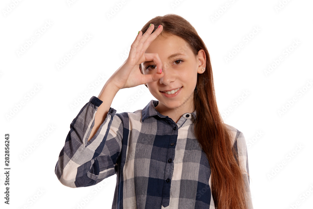 Beautiful teenage girl in a casual checkered shirt is posing isolated on white studio background. Beautiful teenage girl in a casual checkered shirt is posing isolated on white studio background.