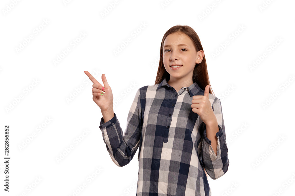 Beautiful teenage girl in a casual checkered shirt is posing isolated on white studio background. Beautiful teenage girl in a casual checkered shirt is posing isolated on white studio background.