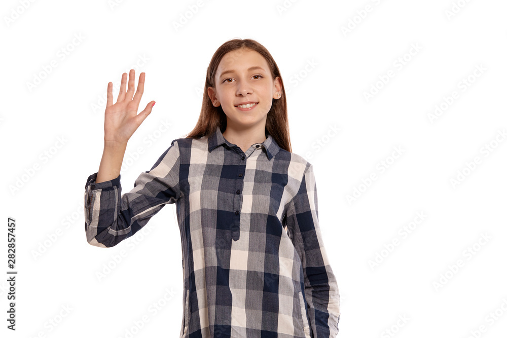 Beautiful teenage girl in a casual checkered shirt is posing isolated on white studio background. Beautiful teenage girl in a casual checkered shirt is posing isolated on white studio background.