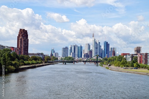 view of the river Main with the european city skyline and financial centre of Frankfurt. Skyscraper buildings in Germany on blue sky background. Business and finance concept