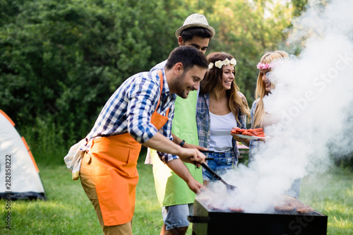 Group of happy friends having outdoor barbecue laughing together
