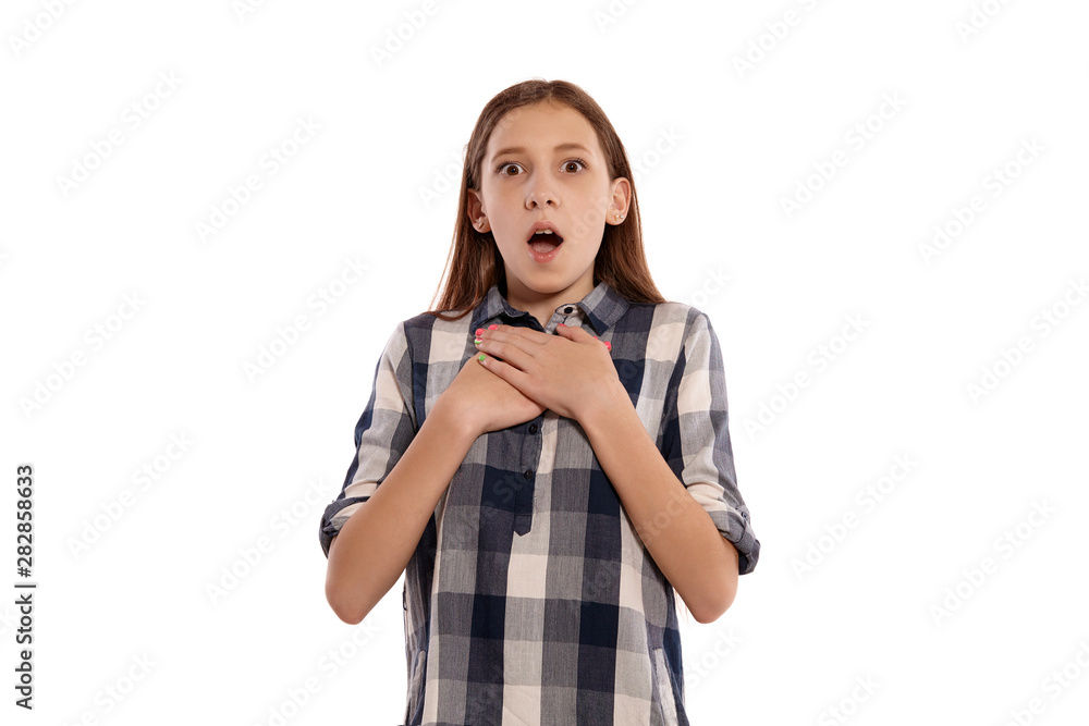 Beautiful teenage girl in a casual checkered shirt is posing isolated on white studio background. Beautiful teenage girl in a casual checkered shirt is posing isolated on white studio background.