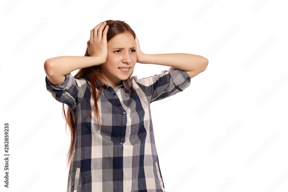 Beautiful teenage girl in a casual checkered shirt is posing isolated on white studio background. Beautiful teenage girl in a casual checkered shirt is posing isolated on white studio background.