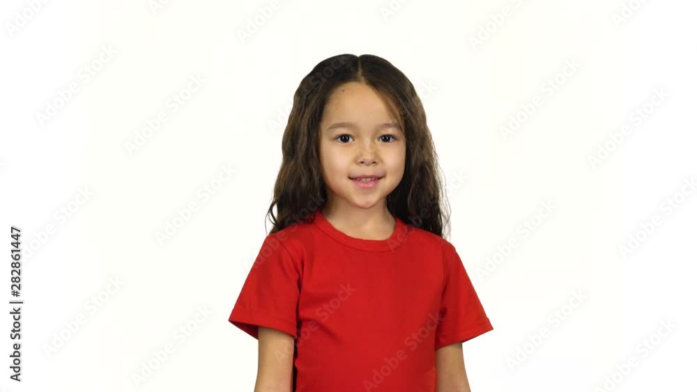 Portrait little dark-haired kid waving with hand on white background Portrait little dark-haired kid waving with hand on white background