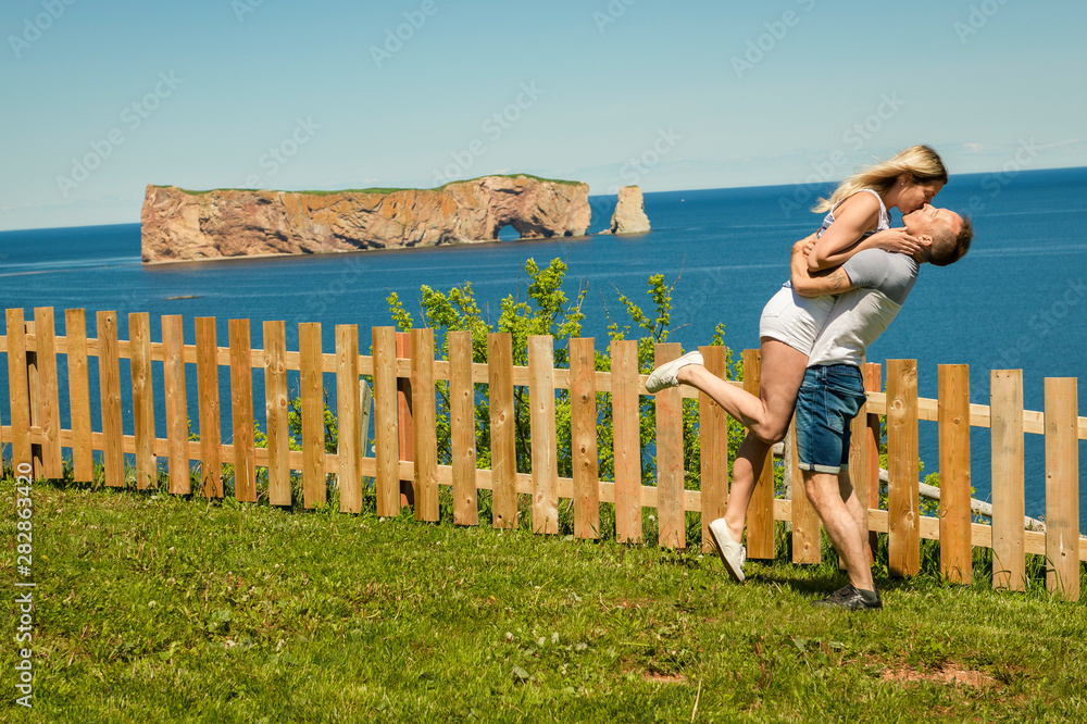 Naklejka premium tourist couple enjoying Perce Rock view from Gaspe in Quebec
