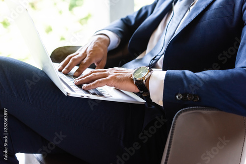 cropped view of businessman in suit using laptop in hotel © LIGHTFIELD STUDIOS