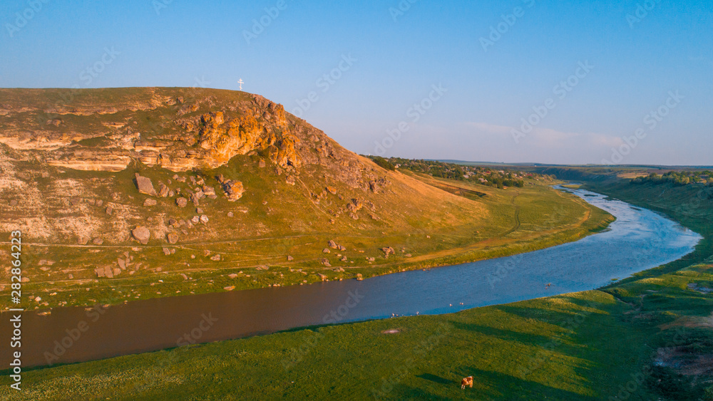 View of a cliff next to a river at sunrise, aerial view.