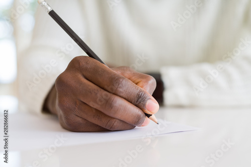 Close up of african man writing a note on a paper