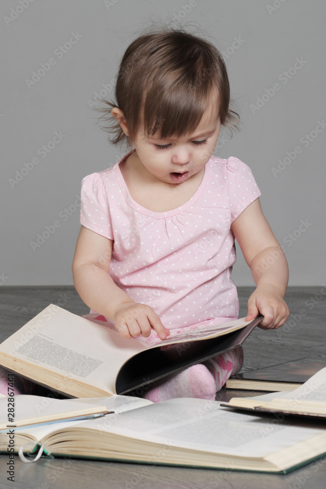little girl sitting on the floor and engaged in self-education little girl sitting on the floor and engaged in self-education