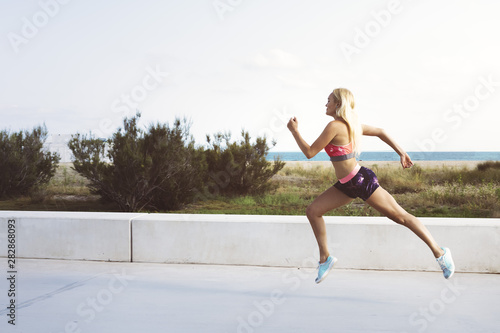 attractive athletic girl running for the promenade