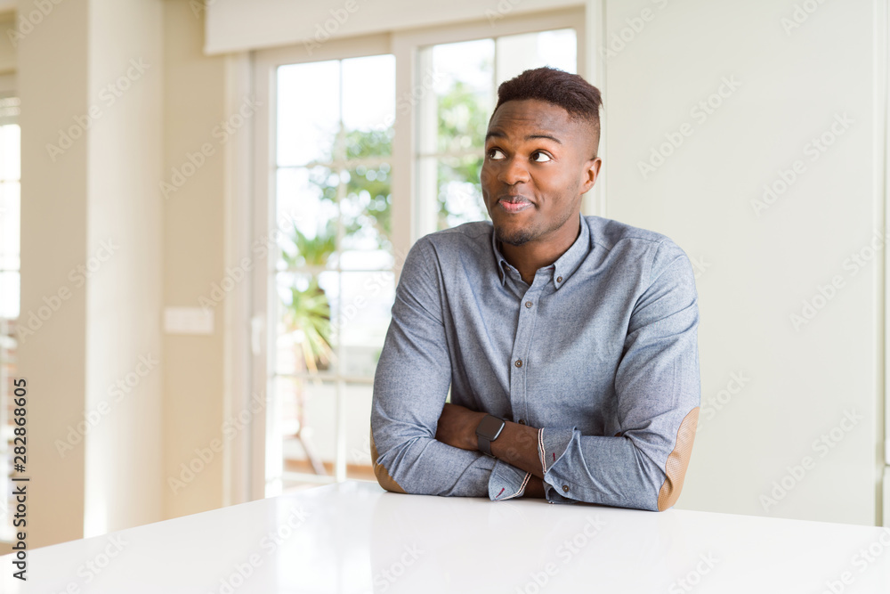 Handsome african american man on white table smiling looking side and staring away thinking. Handsome african american man on white table smiling looking side and staring away thinking.