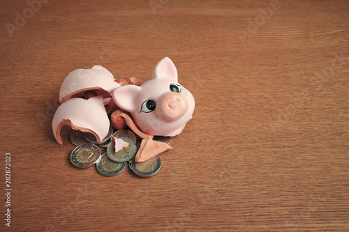 broken piggy bank with euro coins  on the wooden table