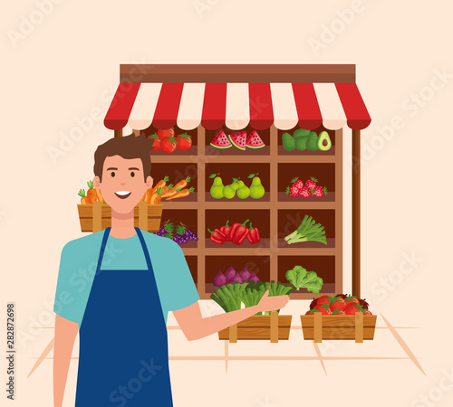 salesman wearing apron with fresh vegetables and fruits