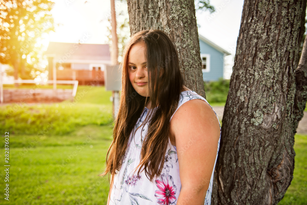 A Portrait of trisomie 21 adult girl outside at sunset A Portrait of trisomie 21 adult girl outside at sunset