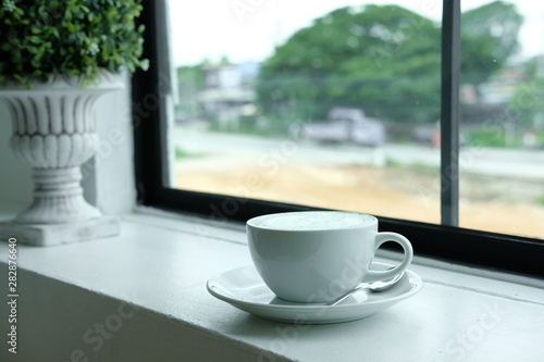 hot matcha green tea latte on wood table.