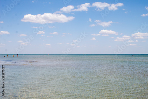 Summer beautiful seascape - transparent sea with a sandy bottom and blue sky, summer breeze.