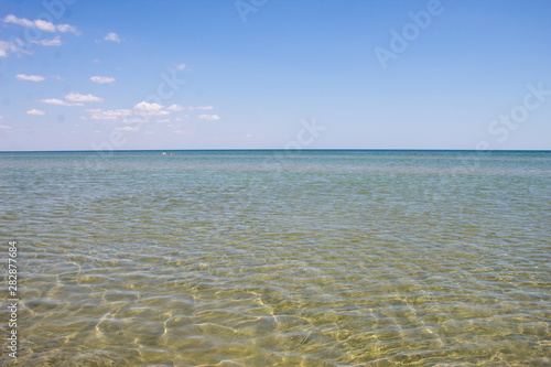 Summer beautiful seascape - transparent sea with a sandy bottom and blue sky  summer breeze.