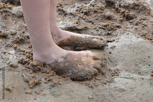 boy plays dirt on the river bank in summer. Active children's holiday outdoor