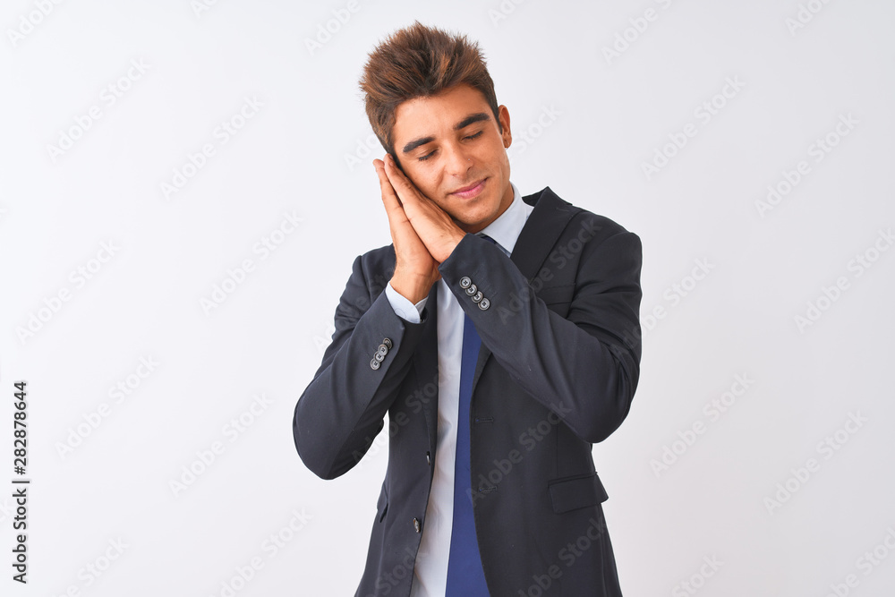 Young handsome businessman wearing suit standing over isolated white background sleeping tired dreaming and posing with hands together while smiling with closed eyes. Young handsome businessman wearing suit standing over isolated white background sleeping tired dreaming and posing with hands together while smiling with closed eyes.