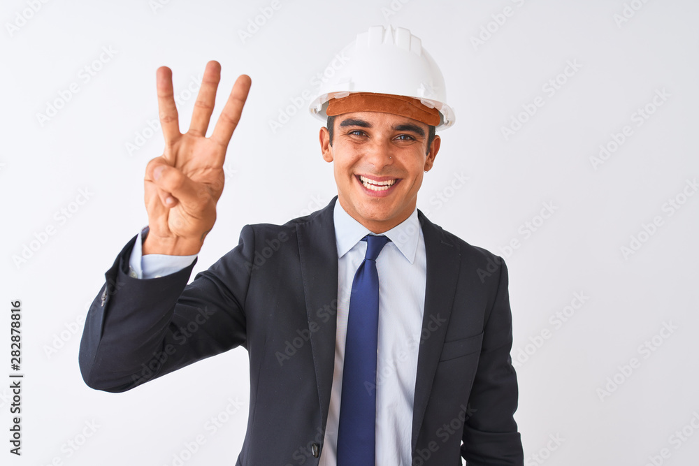 Young handsome architect man wearing suit and helmet over isolated white background showing and pointing up with fingers number three while smiling confident and happy.
