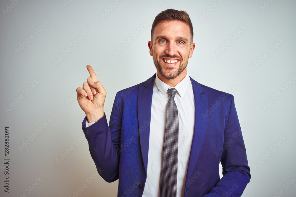 Young handsome business man over white isolated background with a big smile on face, pointing with hand and finger to the side looking at the camera. Young handsome business man over white isolated background with a big smile on face, pointing with hand and finger to the side looking at the camera.