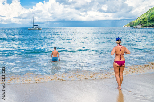 A young couple goes swimming in the sea. 