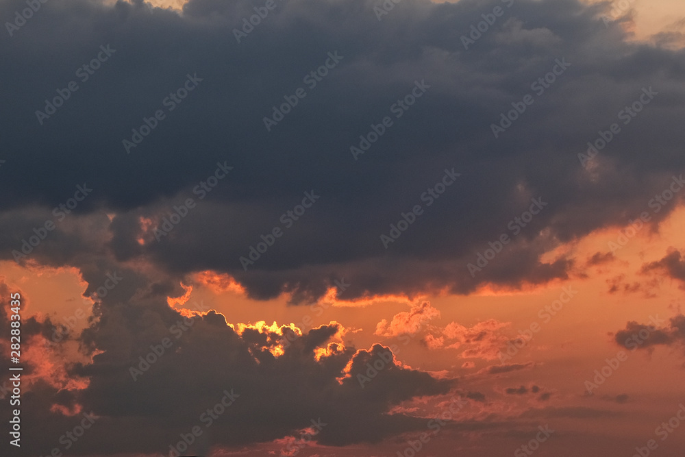 Sunset with dark grey and black clouds, room for copy