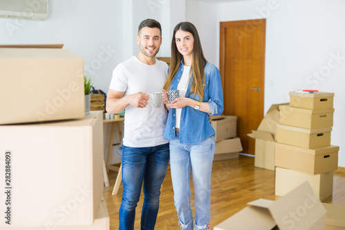 Beautiful couple moving to a new house, smiling cheerful drinking a cup of coffee © Krakenimages.com