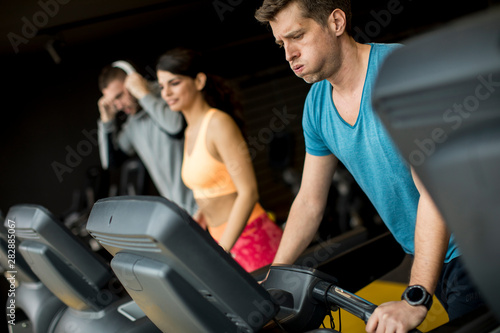 Young people using threadmill in modern gym