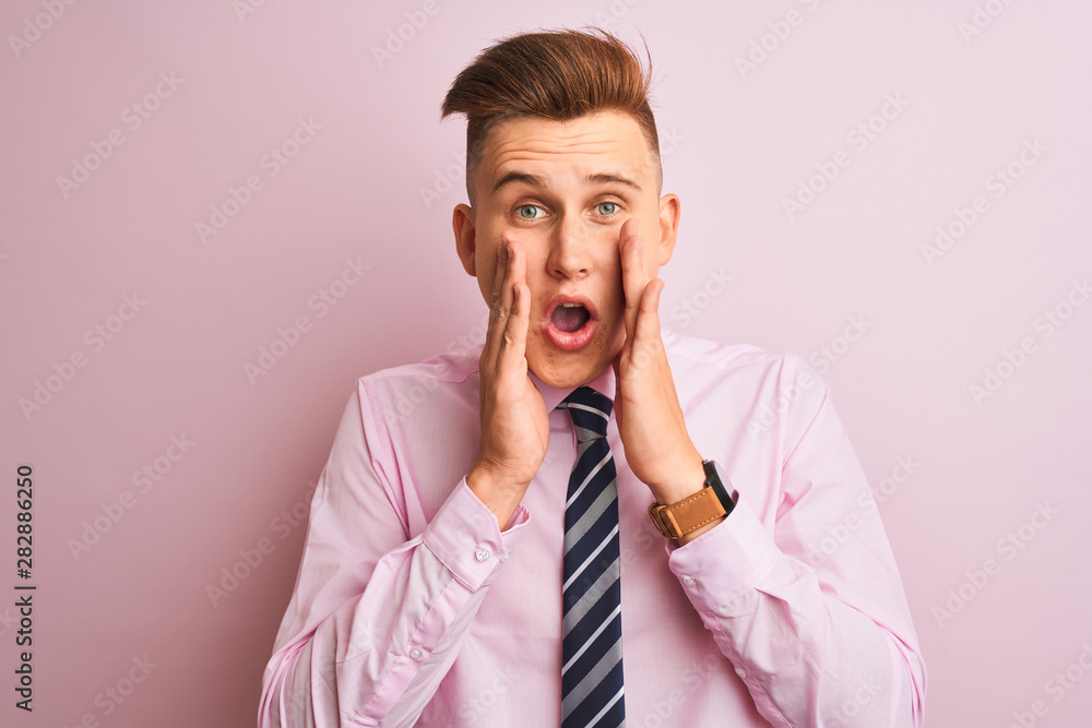 Young handsome businessman wearing shirt and tie standing over isolated pink background afraid and shocked, surprise and amazed expression with hands on face Young handsome businessman wearing shirt and tie standing over isolated pink background afraid and shocked, surprise and amazed expression with hands on face