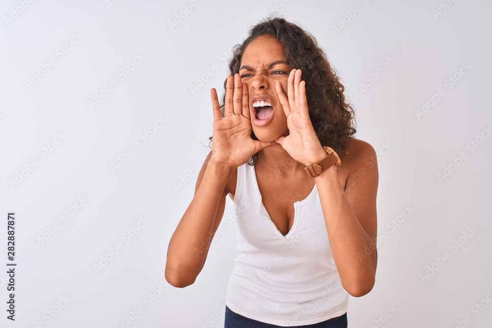 Young brazilian woman wearing casual t-shirt standing over isolated white background Shouting angry out loud with hands over mouth Young brazilian woman wearing casual t-shirt standing over isolated white background Shouting angry out loud with hands over mouth