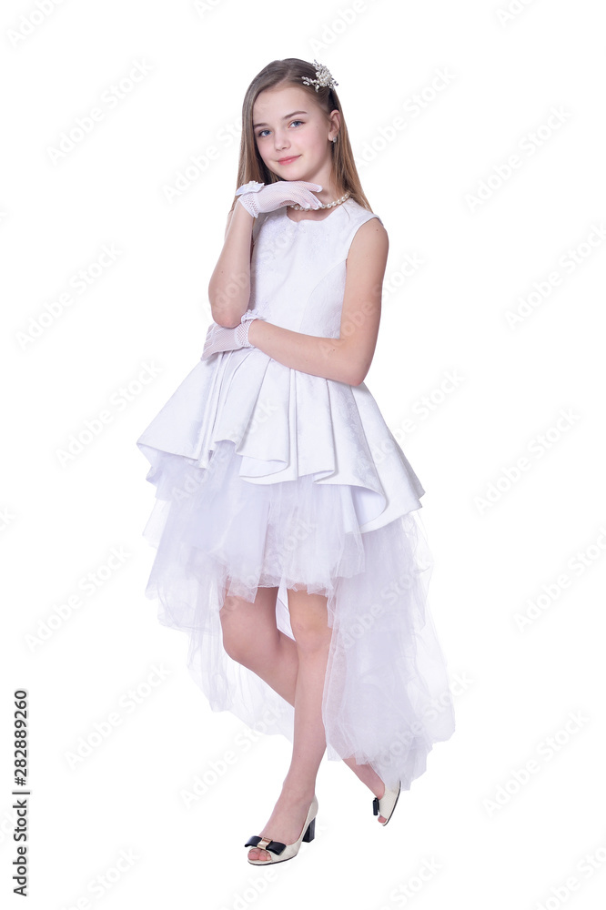 Happy beautiful little girl in white dress posing on white background