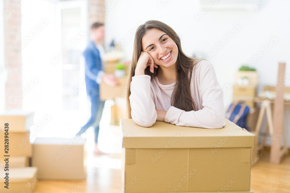 Beautiful young couple moving to a new home, young woman smiling happy to the camera excited for new apartment Beautiful young couple moving to a new home, young woman smiling happy to the camera excited for new apartment