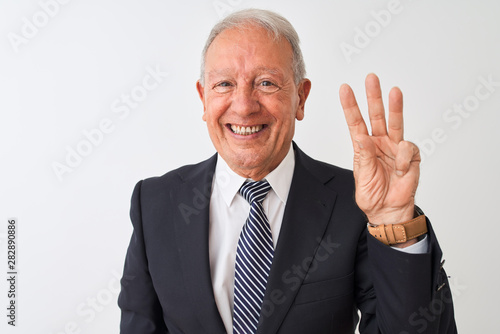 Senior grey-haired businessman wearing suit standing over isolated white background showing and pointing up with fingers number three while smiling confident and happy.