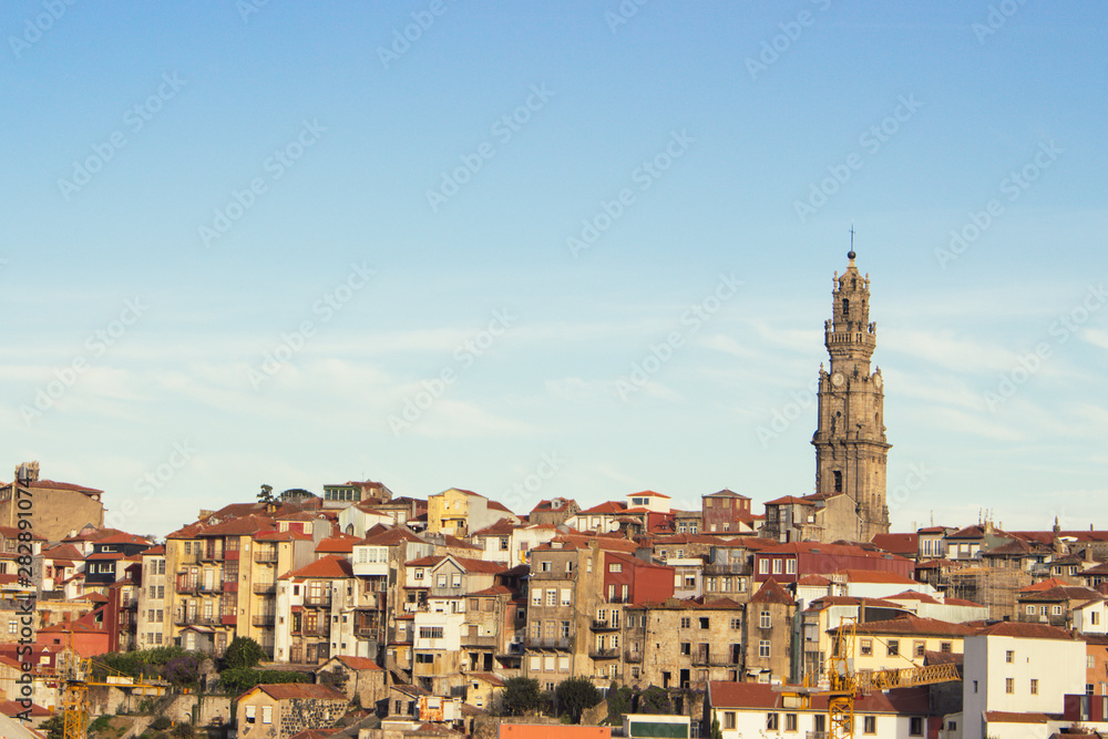 Porto panoramic landmark with church tower on sunny day. Old buildings with red brick roofs in Porto, Portugal. Historic district of Porto. Portuguese vacation. 