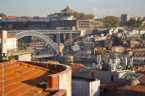 Porto, Portugal - 10/20/2019: Famous Porto bridge Ponte Luis. Porto with bridge, church and brick red roofs. Porto landmark on sunny day. Summer travel. Portuguese vacation. photo