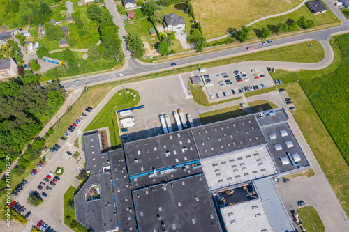 Aerial view of goods warehouse. Logistics center in industrial city zone from above. Aerial view of trucks loading at logistic center photo