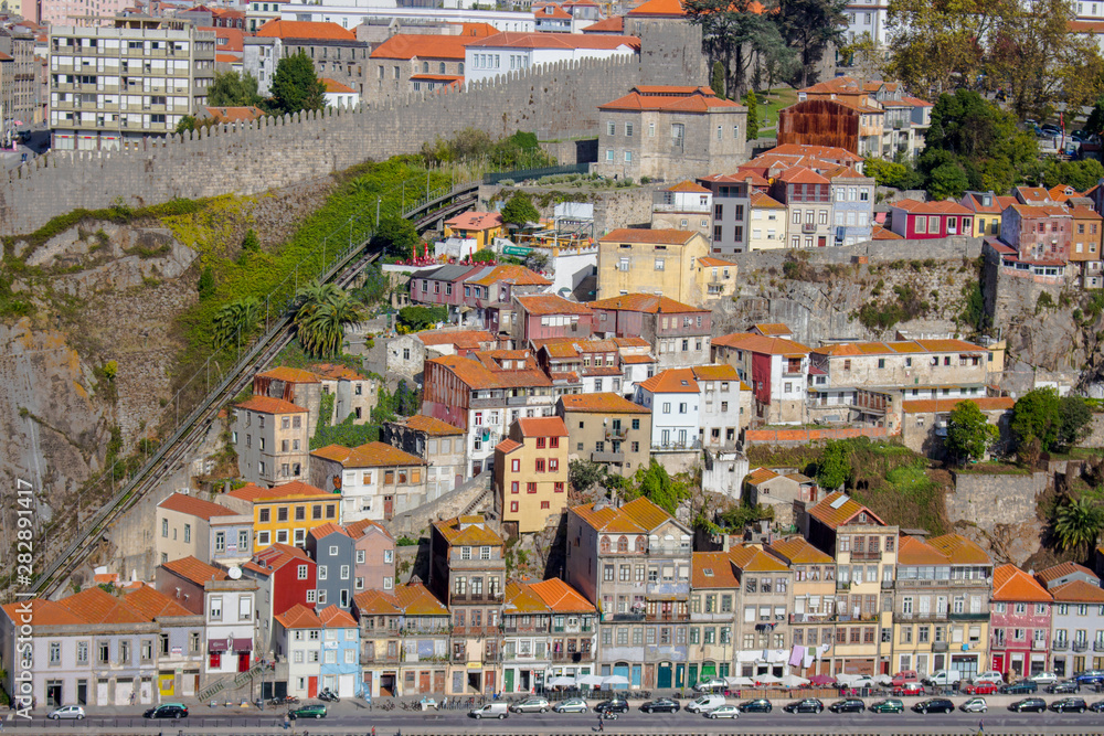 Porto panoramic landmark on sunny day. Old buildings with red brick roofs on the hill in Porto, Portugal. Historic district of Porto in morning light. Portuguese vacation.
