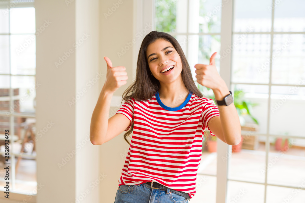 Beautiful young woman smiling excited doing thumbs up symbol, ok gesture Beautiful young woman smiling excited doing thumbs up symbol, ok gesture