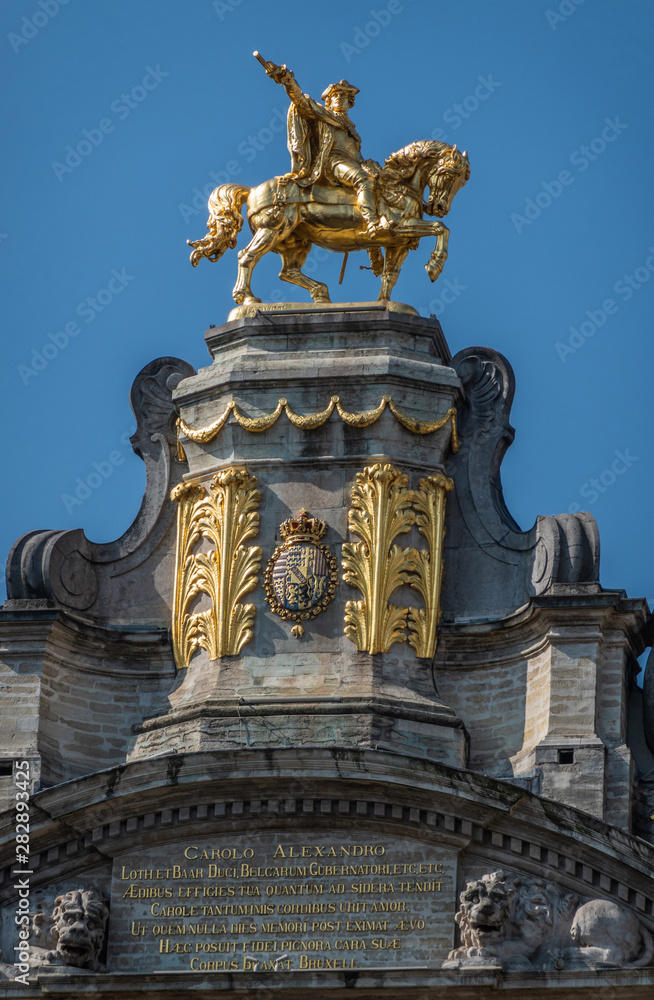 Brussels, Belgium - June 22, 2019: Closeup of gulden statue of Charles Alexander of Lorraine on top of L’Arbre D’Or house on Grand place against blue sky.